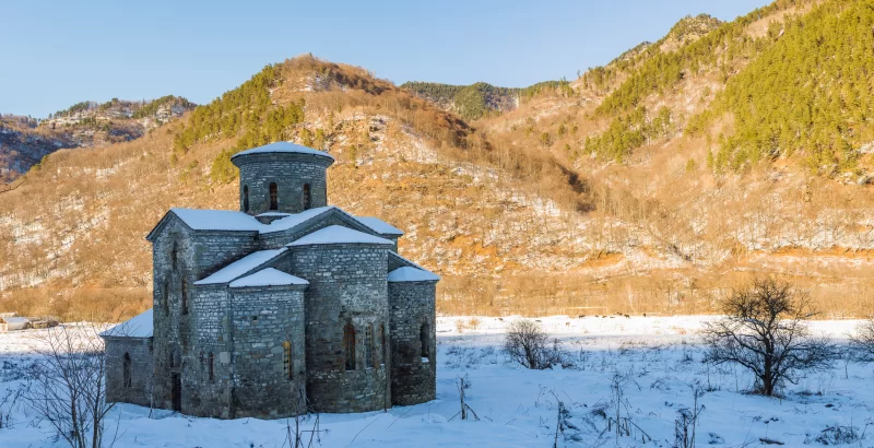 Древний заброшенный православный храм в зимних горах Северного Кавказа.