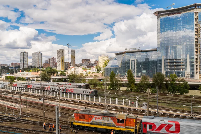 Современный городской вокзал: поезда на путях и деловой центр