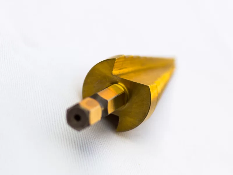 Золотой ступенчатый сверло на белом фоне, макросъемка