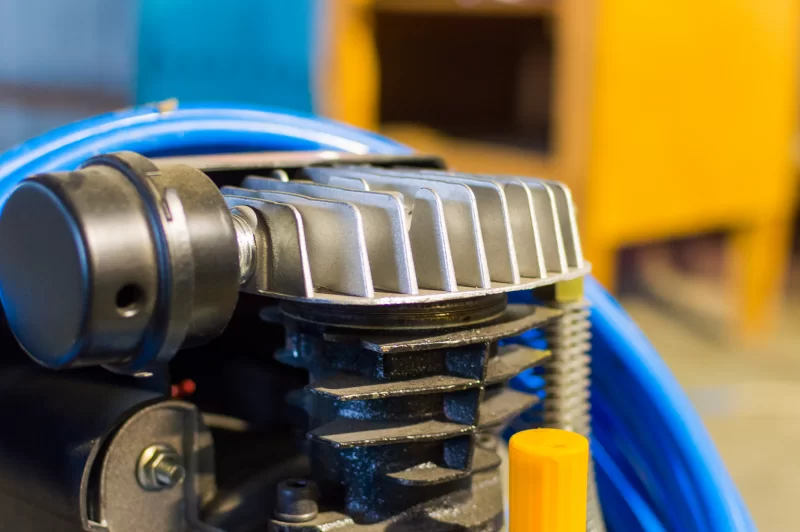 Детали синего воздушного компрессора в мастерской