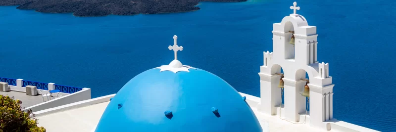 Церкви с голубыми куполами над Средиземным морем на острове Санторини.