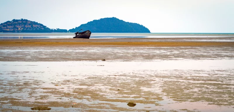 Старая лодка села на мель во время отлива