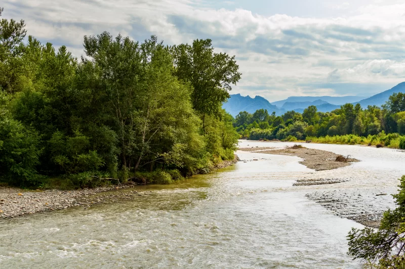 Величественная река среди горных пейзажей и пышной зелени