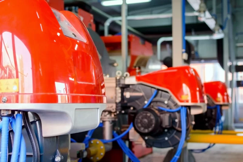 Современное промышленное оборудование: ярко-красные горелки в производственном цеху