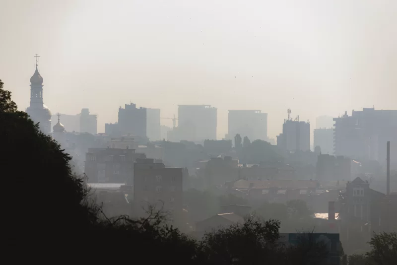 Вид на город в утреннем тумане. Промышленный туман на городском пейзаже.