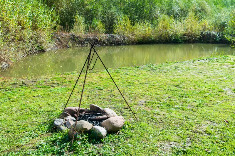 Деревенский костер с треногой у пруда