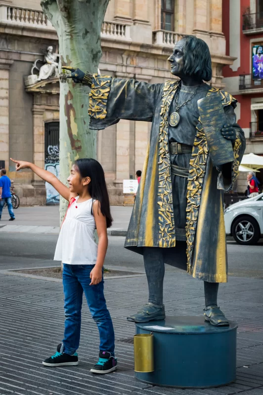 Статуя Христофора Колумба и девочка на улице Рамбла в Барселоне