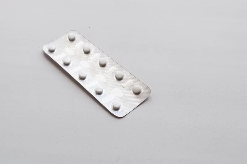 Blister pack with white pills on a light background