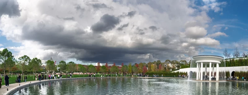 Park with fountain and pond, people walking