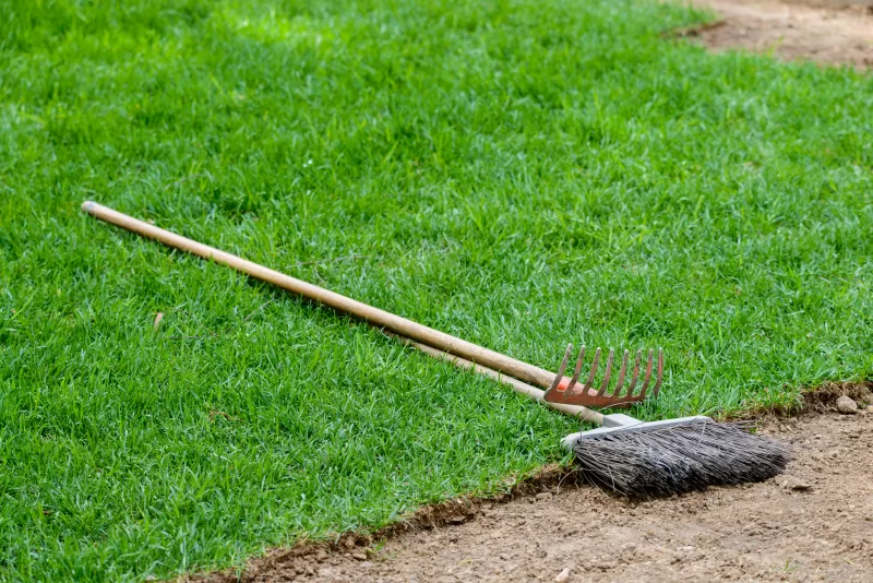 Инструменты, грабли и метла на газоне