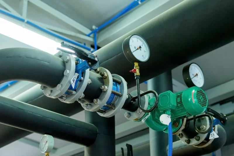Промышленная система трубопроводов с манометрами и насосом