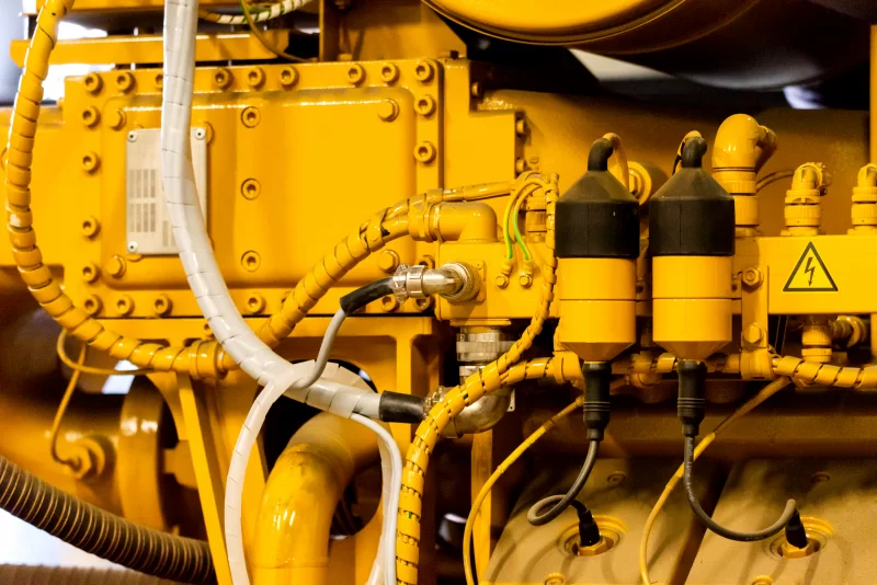 Крупный план желтого промышленного двигателя: детали, провода и символы