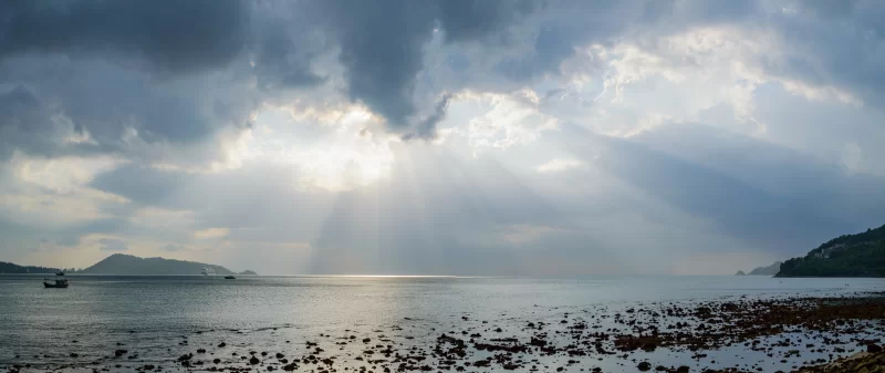 Лучи света, пробивающиеся сквозь темные тучи