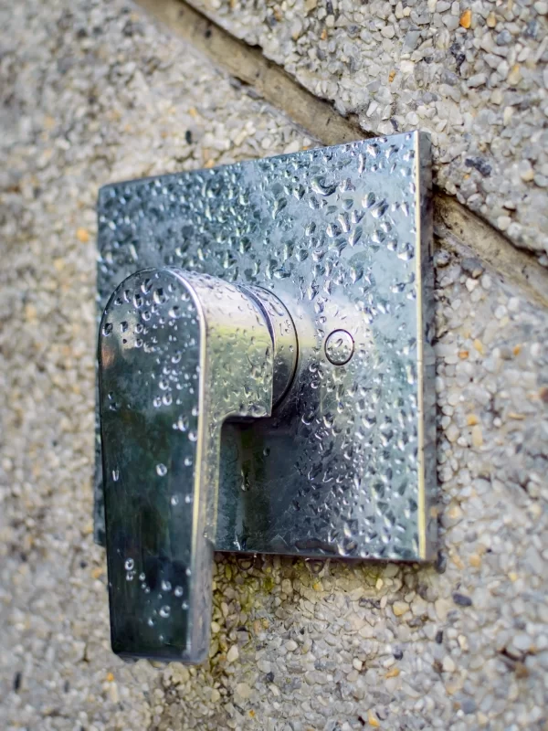 Shower tap faucet in chrome on stone wall