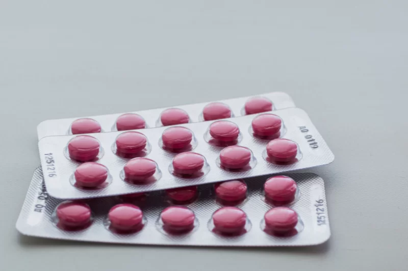 Две упаковки розовых таблеток на блистерной упаковке