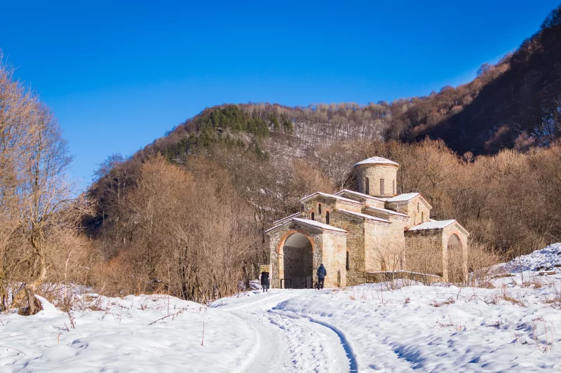 Зимний пейзаж с древним христианским храмом в горах