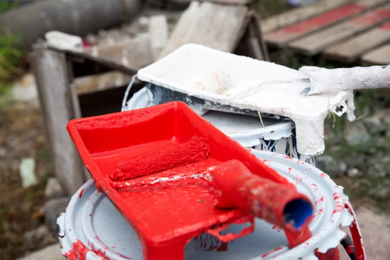 Инструменты для покраски: красная и белая краска, валики и емкости