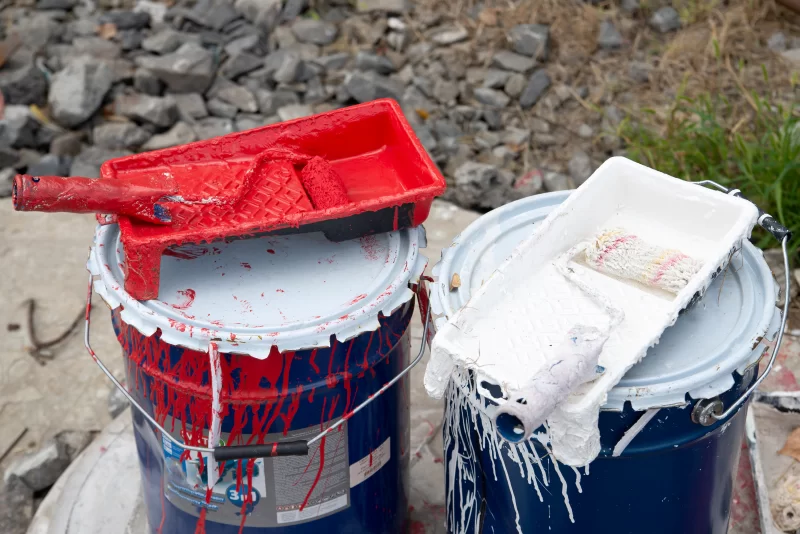 Рабочие инструменты для покраски: ведра с краской и лотки с валиками