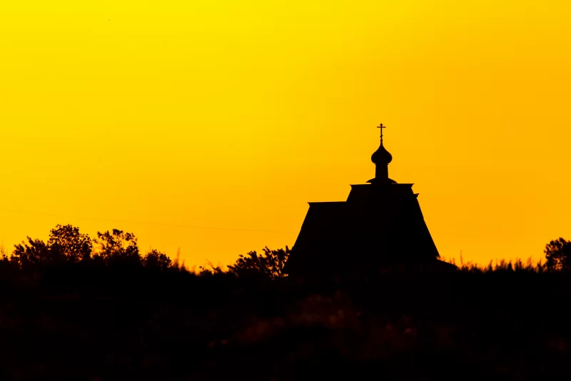 Силуэт креста церкви на закате на фоне закатного неба
