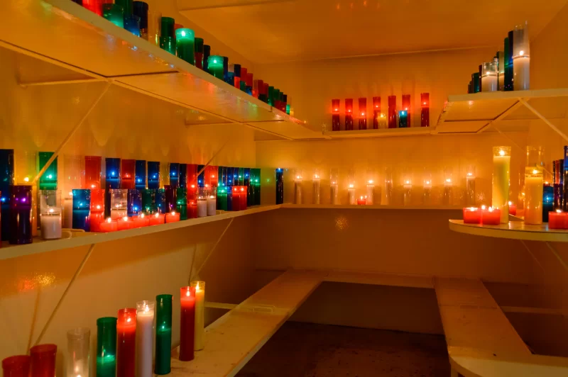 Красочные свечи с пламенем на полках в маленькой комнате.