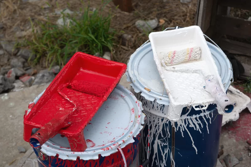 Инструменты для покраски: красная и белая краска, валики и банки