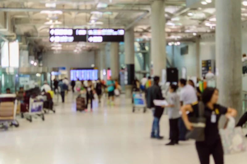 Оживленный аэропорт: люди, багаж и табло вылетов в современном терминале