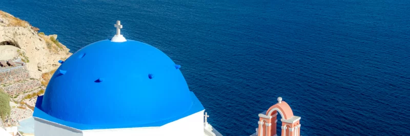 Церкви с голубыми куполами над Средиземным морем на острове Санторини.