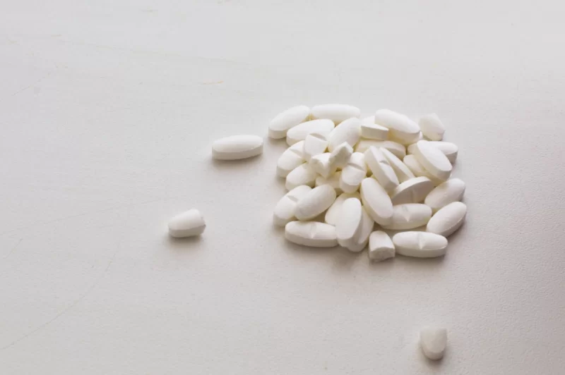 Белые таблетки на светлом фоне: крупный план