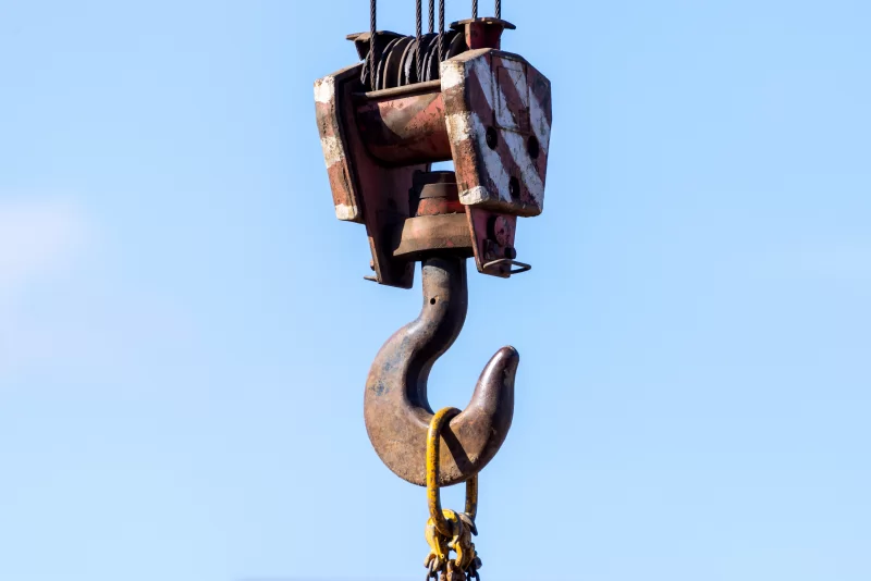 Мощный грузовой крюк крана на фоне чистого голубого неба