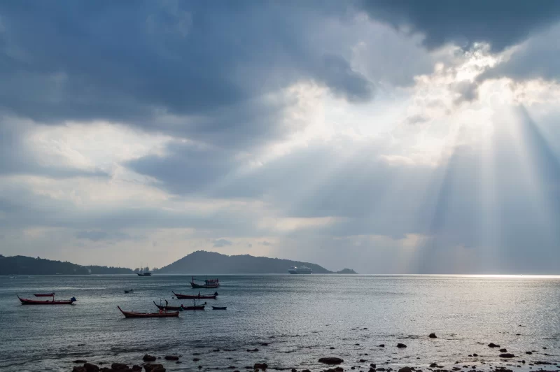 Лучи света, пробивающиеся сквозь темные тучи