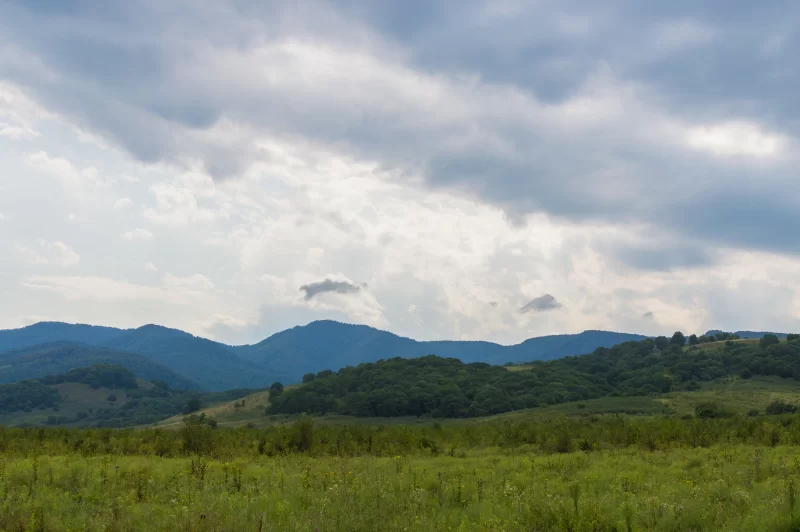 Величественный горный пейзаж с облаками и зелеными холмами