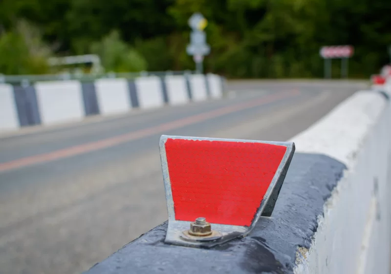 Красный отражатель на ограждении дороги