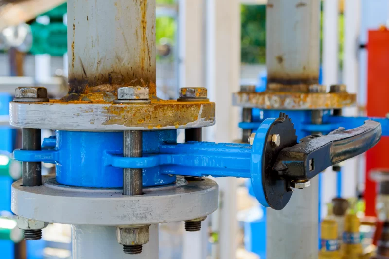 Промышленный трубопровод с синим вентилем и ржавыми фланцами