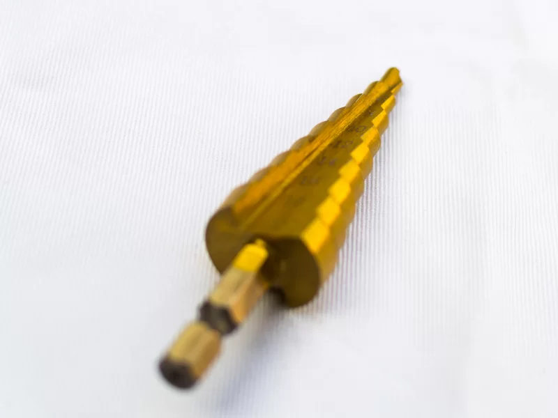 Золотая ступенчатая сверло на белом фоне