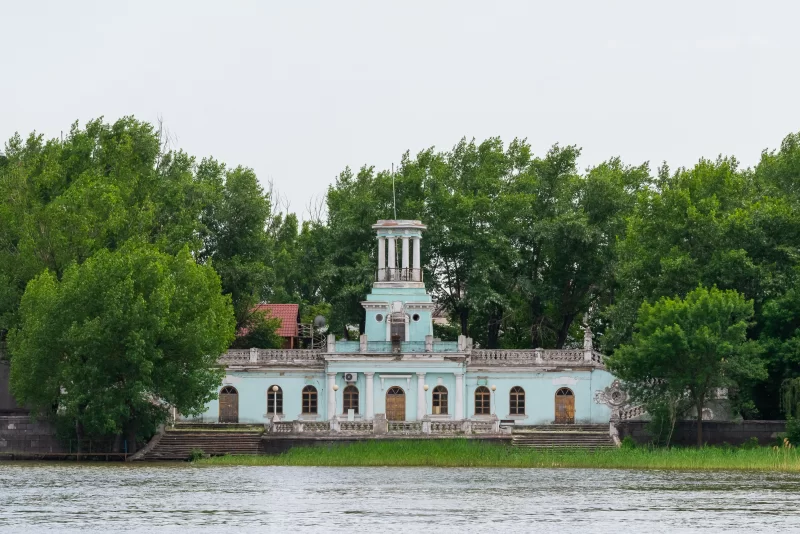 Живописный пейзаж со старинным зданием на берегу реки