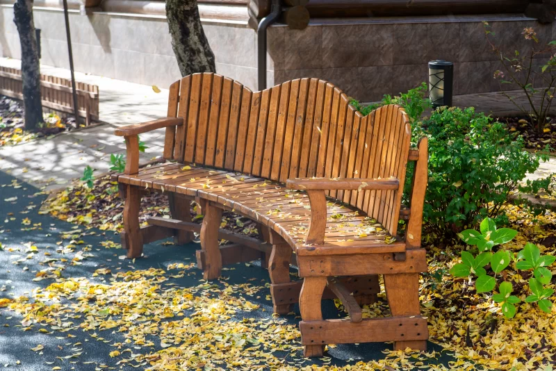Деревенская деревянная скамейка в осеннем парке