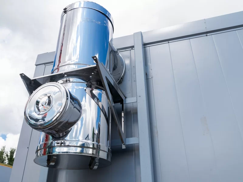 Блестящая металлическая вытяжная труба на современном здании