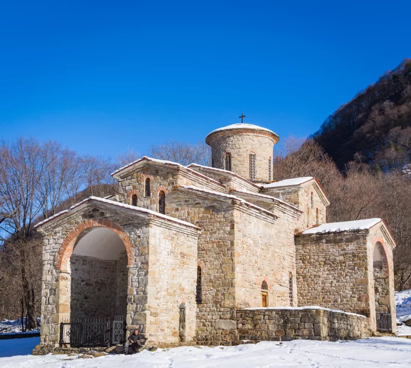 Древний храм в снегу под голубым небом
