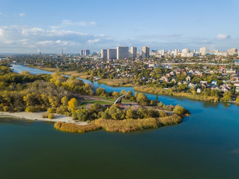 Живописный осенний пейзаж с рекой, городом и парком