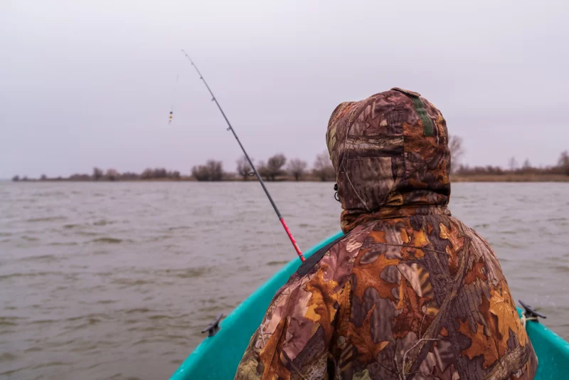 Fisherman in a boat on a cloudy day, waiting for a catch
