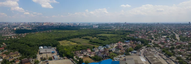 Панорамный вид на город с высоты птичьего полета: сочетание зелени, жилых домов и промышленных зон