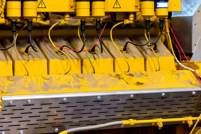 Детали мощного промышленного дизельного двигателя: крупный план желтых цилиндров и проводки