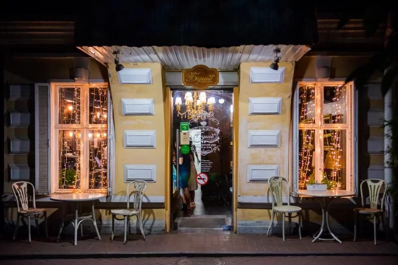 Уютное кафе вечером: вечерняя подсветка и столики на улице