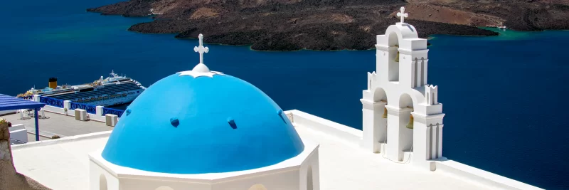 Церкви с голубыми куполами над Средиземным морем на острове Санторини.