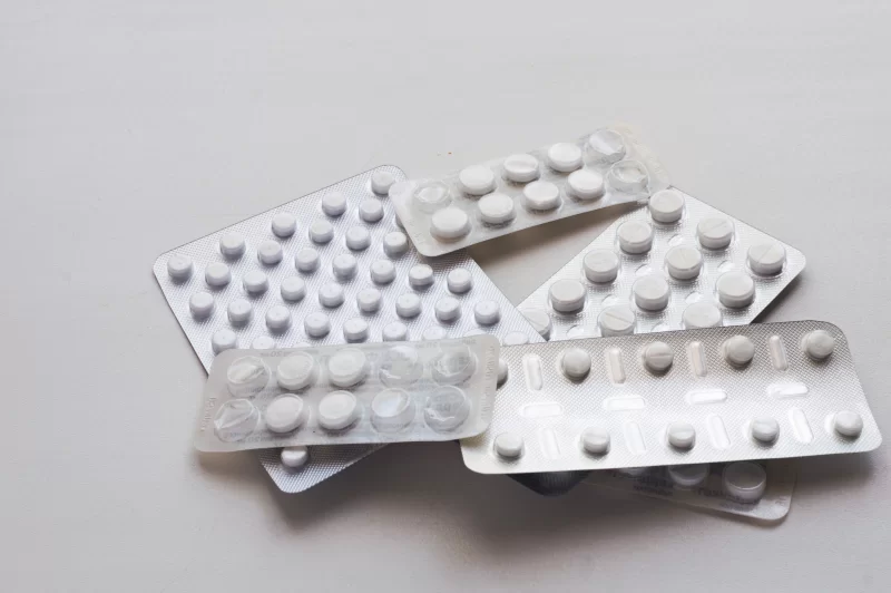 Блистеры с таблетками и капсулами на светлом фоне
