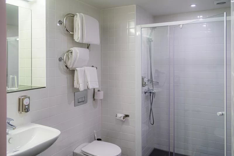 Современный и чистый номер отеля: ванная комната с душем, раковиной и туалетом