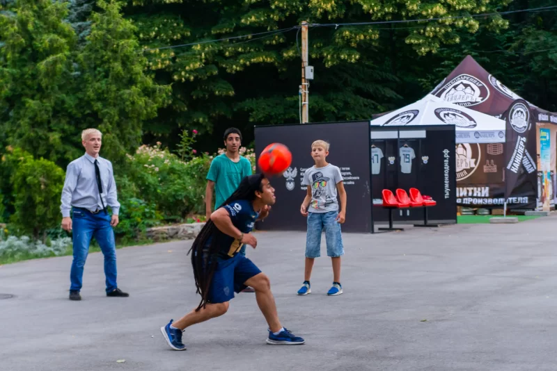 Группа счастливых молодых людей из разных стран играет с мячом